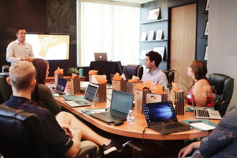 A team meeting around a table with laptops